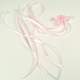 Roze corsage met linten.